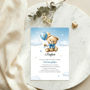 Kék lufis kismaci meghívó márvány felületen, arany szív kiegészítővel, selyem drapériával és eukaliptusz ággal.